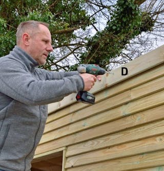 Lodräta intäckningarna skruvas fast på förråd De lodräta intäckningarna skruvas fast längs sidorna på förråd